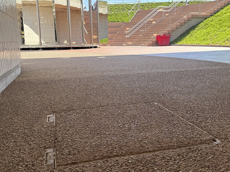 ACO Toptek Assist pokrov z asistenco za odpiranje v skoraj 40 metrov dolgem in 8 m širokem podhodu Vrtača s kupolo Ingeborg Bachman v ozadju